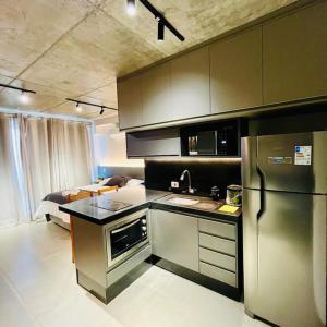 a kitchen with a stainless steel refrigerator and a sink at Studio em Maringá in Maringá