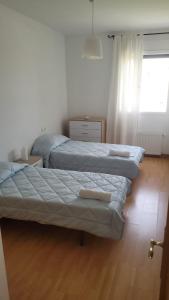 a bedroom with two beds and a window at Apartamento Cattleya in Almazán