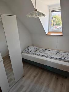 ein kleines Schlafzimmer mit einem Bett und einem Spiegel in der Unterkunft Apartmaji Pri Kokolu in Bled