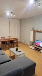 ein Wohnzimmer mit Sofa, Tisch und Fernseher in der Unterkunft Casa Cattleya in Almazán