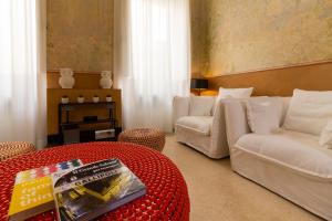 a living room with white couches and a red table at Casa Galateo 20 in Gallipoli