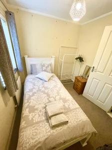a bedroom with a bed with two towels on it at Cozy single room in city center in Newry