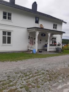 una casa blanca con un perro en el porche en Täljelantgårdshotell en Tälje