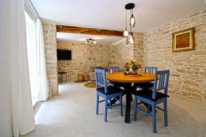 a dining room with a wooden table and blue chairs at Ferienhaus für 6 Personen ca 100 qm in Rakalj, Istrien Bucht von Raša in Rakalj +14 photos
