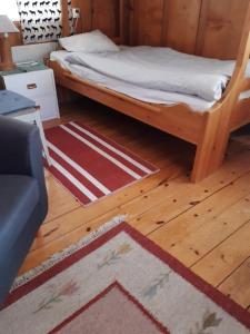 a bedroom with a bed and a rug on a wooden floor at Täljelantgårdshotell in Tälje