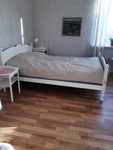 a bedroom with a bed and a wooden floor at Täljelantgårdshotell in Tälje