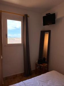 a bedroom with a window and a bed and a mirror at Appartement T2 tout équipé in Port Leucate