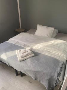 Una cama blanca con una toalla encima. en Pensjonat "U Aktorów", en Elbląg