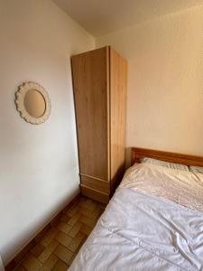 a bedroom with a bed and a wooden cabinet at Appartement T2 tout équipé in Port Leucate