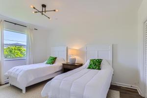 een witte slaapkamer met 2 bedden en een raam bij The Glenn House Vacation Home - New in West Palm Beach