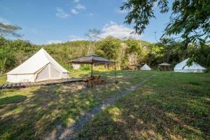 eine Gruppe von Zelten auf einem Feld mit einem Tisch in der Unterkunft Glamchette Okayama -Glamping & Auto Camp- - Vacation STAY 19593v in Mimasaka