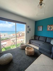een woonkamer met een bank en uitzicht op de oceaan bij Jandia Beach in Morro del Jable