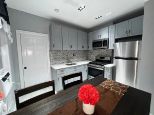 uma cozinha com uma mesa com uma flor vermelha em 3 bedrooms in Modern Brooklyn home, Close to J train em Brooklyn