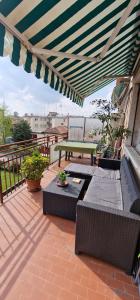 d'une terrasse avec des canapés et une table de pique-nique sur un balcon. dans l'établissement Casa A.N.N.E., à Marghera