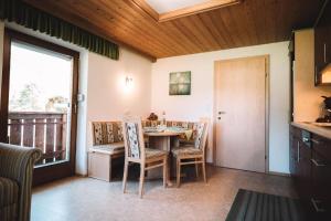 a dining room with a table and chairs and a window at Ferienwohnung Lechtal mit 2 Schlafzimmer und großem Balkon in Bach