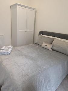 ein weißes Schlafzimmer mit einem Bett und einem weißen Schrank in der Unterkunft Contemporary Double Ensuite Room in Birmingham