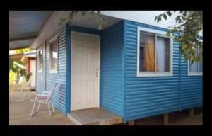 a blue tiny house with a chair on a porch at Cabañas Las Olas in Constitución