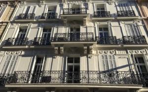 un edificio alto de color blanco con balcones en un lateral. en CENTRAL 1BR IN CANNES, en Cannes