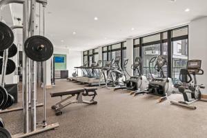 a gym with a row of treadmills and machines at Luxurious Urban Retreat with Amazing Amenities in Tampa