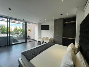 ein Schlafzimmer mit einem großen Bett und einem Balkon in der Unterkunft Hotel 47 Medellin Center in Medellín
