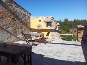 a patio with a table and chairs on a stone building at LES ANGES in Covelo