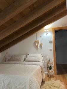 a bedroom with a white bed and a wooden ceiling at B&B Il Gufo in Erto
