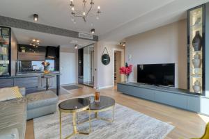 a living room with a couch and a tv at Prestige Views: Luxury Retreat in Bucharest