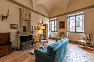 uma sala de estar com um sofá azul e uma lareira em Palazzo Costanti - A 8 minuti dalle terme em San Quirico dʼOrcia