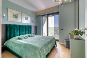 a bedroom with a green bed and a large window at Prestige Views: Luxury Retreat in Bucharest