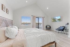 a white bedroom with a large bed and a window at * Large Updated Waterfront Delta Manor Boat Dock * in Discovery Bay