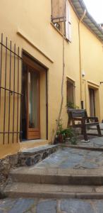 - un bâtiment avec une porte et un banc à côté dans l'établissement Studio du pêcheur, à Collioure