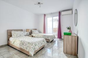 a bedroom with two beds and a window at Brand New 2 Bed 2 Bath Apartment In Sliema By The Sea in Sliema