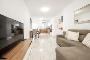 een woonkamer met een bank en een tafel bij Brand New 2 Bed 2 Bath Apartment In Sliema By The Sea in Sliema