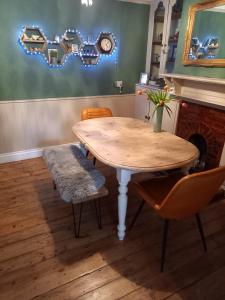 a wooden table and chairs with a table and a fireplace at Allington Hill-Bridport, Dorset in Bridport