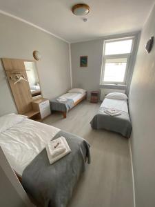 um quarto com 2 camas e um espelho em Pensjonat "U Aktorów" em Elblag