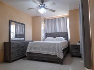 1 dormitorio con 1 cama y ventilador de techo en Seville Meadows 3 - Johns Road Spanish Town, en Spanish Town