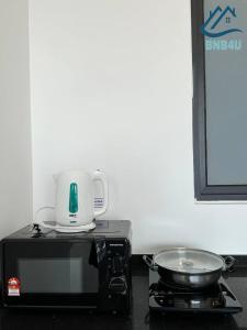 a microwave oven with a pot on top of it at Urban Suites @ George Town Penang by BNB4U in George Town
