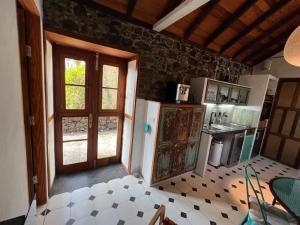 uma cozinha com um frigorífico, uma mesa e uma porta em Casa Jardín Tropical em Los Llanos de Aridane