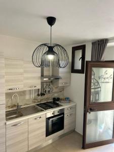 a kitchen with a stove and a chandelier at La Cupola - casa vacanze n 10 in Termini Imerese