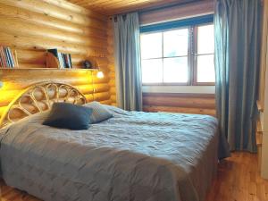 um quarto com uma cama e uma parede de madeira em Holiday Home Honkakoli 1 em Kolinkylä