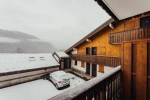 a car parked outside of a house in the snow at Punta Helbronner Furnished studio in Saint-Gervais-les-Bains