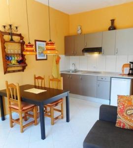 a kitchen with a table and chairs in a room at Liebevoll eingerichtet, ruhiges Ferienapartment mit separatem Schlafzimmer in La Pared