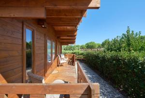 a porch of a wooden house with a table and chairs at Lakeside Cabin Oasis w/ AC, By TimeCooler in Montargil