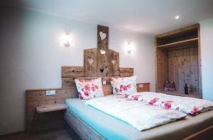 1 dormitorio con 1 cama grande y cabecero de madera en Apartment "OBERBACH" für 2 Personen mit Blick auf die Berge en Bach