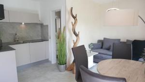 Herdwangen-SchönachにあるNettes Appartement in Herdwangen-Schönach mit Kleiner Terrasseのキッチンとテーブルとソファのあるリビングルーム
