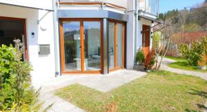 une maison avec des portes en verre sur son côté dans l'établissement Nettes Appartement in Herdwangen-Schönach mit Kleiner Terrasse, à Herdwangen-Schönach