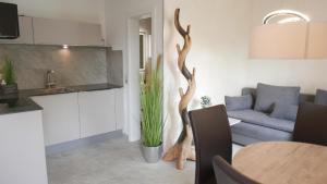 Herdwangen-SchönachにあるNettes Appartement in Herdwangen-Schönach mit Kleiner Terrasseのキッチンとテーブルのあるリビングルーム