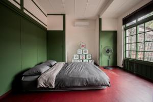 a bedroom with green walls and a bed in it at Xinghua Room in Kaohsiung