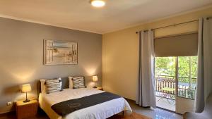 アルブフェイラにあるBicos 303 by Check-in Portugalのベッドルーム1室(ベッド1台付)、窓、バルコニーが備わります。