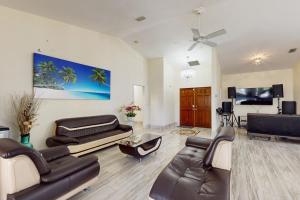 a living room with leather furniture and a flat screen tv at Palms on the Canal in Cape Coral